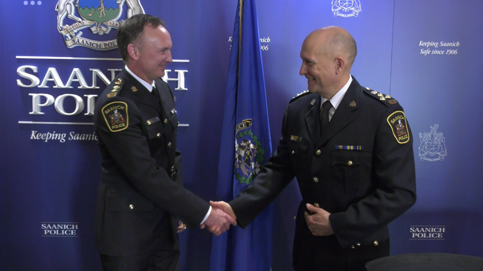 Incoming Saanich Chief Constable, Deputy Police Chief Dean Duthie (left), gets a congratulatory handshake from current Saanich Police Chief Scott Green. (CTV News.)