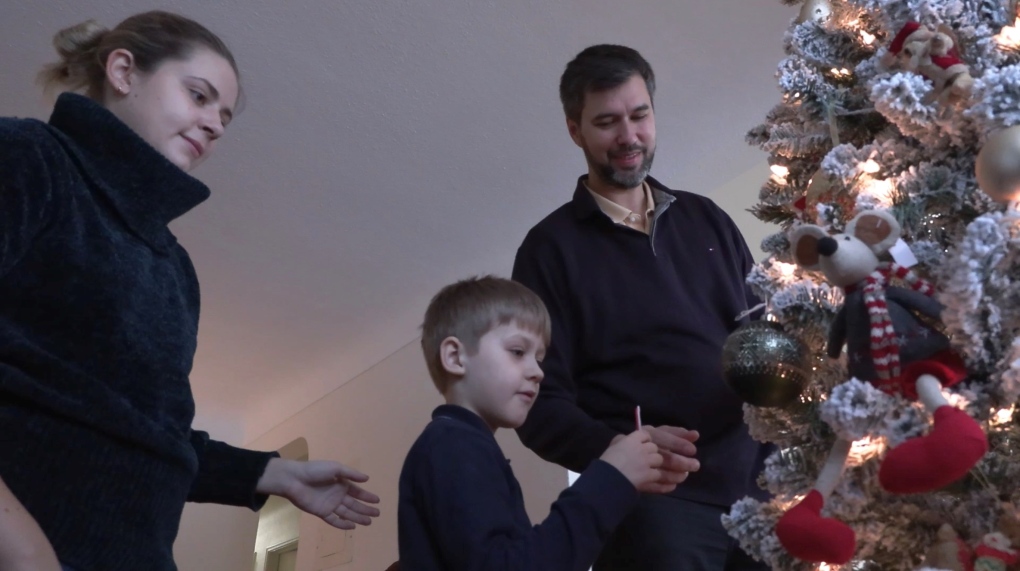 Anton Kostin, Savva Kostin and Kat Malkina decorate their Christmas tree in Victoria. (CTV)
