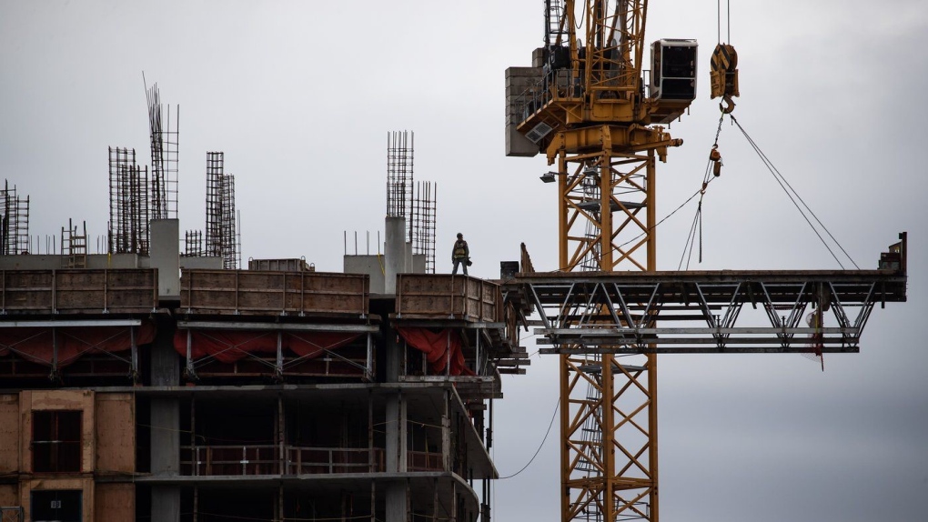 A tradesperson stands atop a condo tower under construction, in Burnaby, B.C., on Wednesday, March 2, 2022. (THE CANADIAN PRESS/Darryl Dyck)