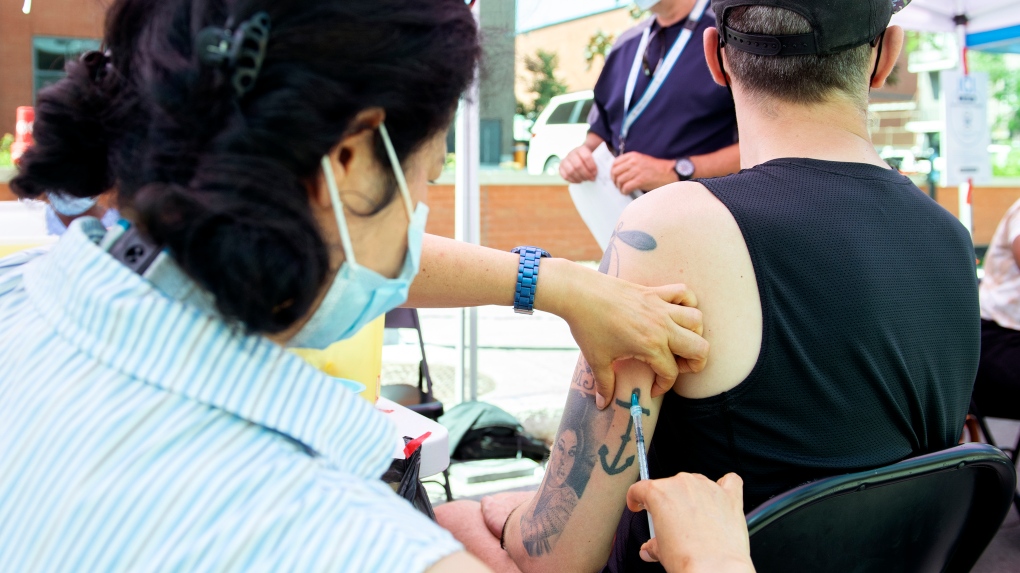Brian Maci from New York receives a monkeypox vaccine at an outdoor walk-in clinic in Montreal, Saturday, July 23, 2022. THE CANADIAN PRESS/Graham Hughes