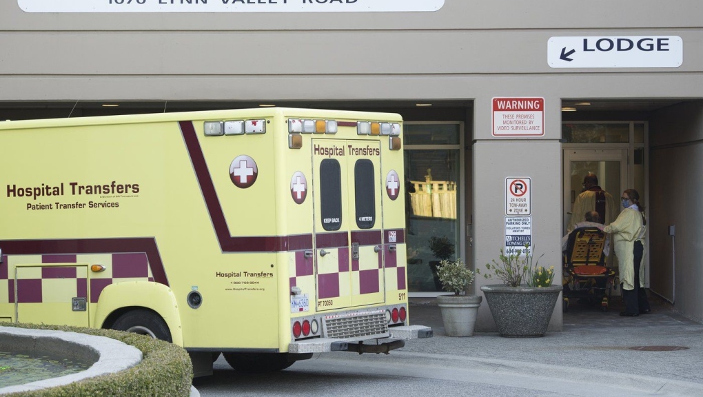 Hospital transfer workers are seen outside the Lynn Valley Centre care home in North Vancouver, B.C., on Wednesday, April 8, 2020. (THE CANADIAN PRESS/Jonathan Hayward)